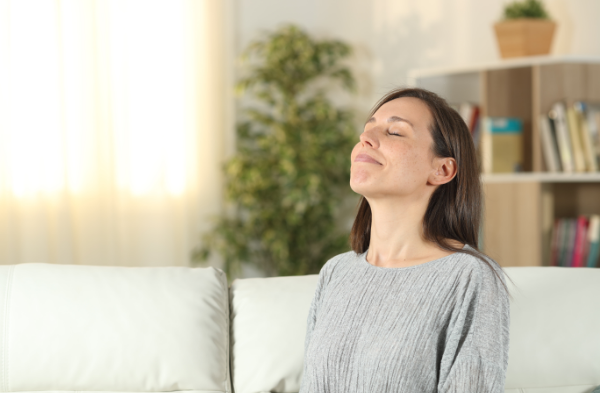 Relaxed woman breathing fresh indoor air from houseplants
